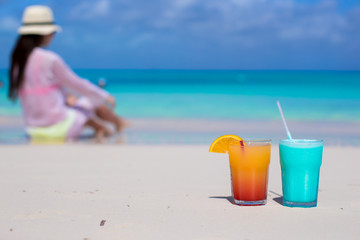Close up tasty cocktails on beach background young woman