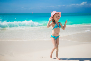 Fototapeta na wymiar Adorable little girl in hat at beach during caribbean vacation