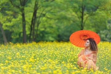 Beautiful woman holding a parasol in a meadow