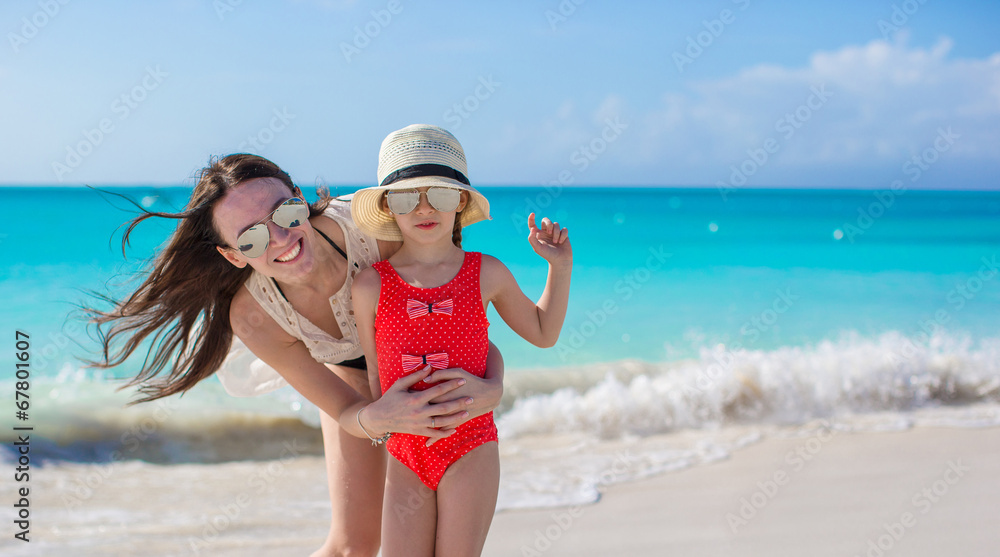 Wall mural Mother and little kid at beach on sunny day