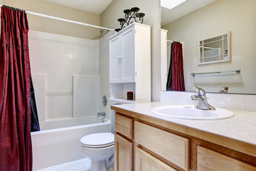 White bathroom interior with burgundy curtain