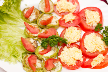 Sliced tomato with cheese sauce and fried marrow squash