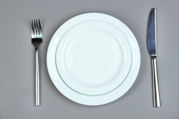 Knife, color plate and fork, on color background