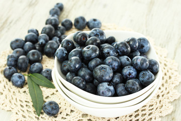 Blueberries in plates on napkin on wooden background