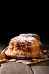 Tasty cakes on table on black background