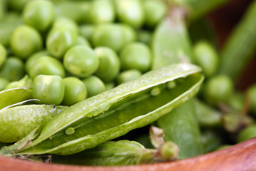 Green peas in wooden bowl, close-up