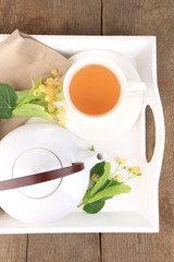 Tasty herbal tea with linden flowers on wooden table