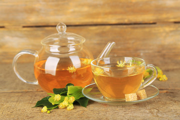 Tasty herbal tea with linden flowers on wooden table