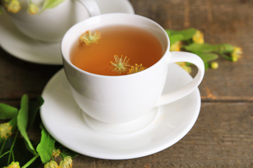 Tasty herbal tea with linden flowers on wooden table