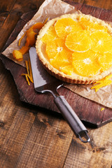 Homemade orange tart on wooden background
