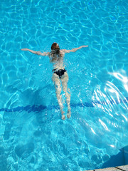 woman with swimsuit swimming on a blue water pool