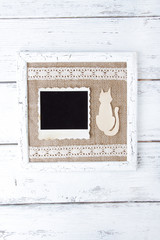 Wooden frame with blank old photo and paper cat