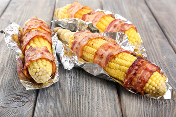 Grilled bacon wrapped corn on table, close-up