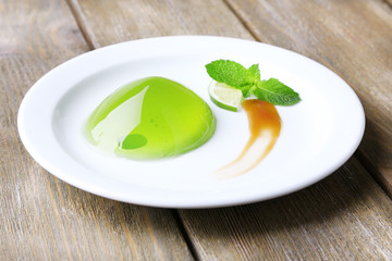 Green jelly with mint leaves on wooden background