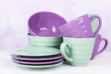 Bright dishes on table on bright background