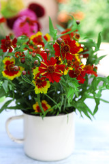 Beautiful Rudbeckia flowers in vase on wooden table, outdoors