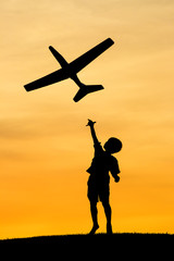 Fototapeta na wymiar Boy launches toy plane.