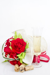 glasses of white wine and bouquet of roses