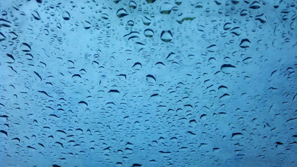 Water raining on window glass close up background texture