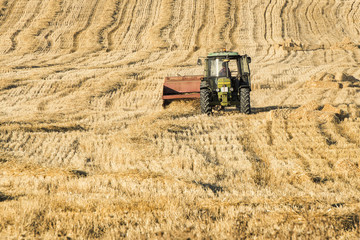 Tractor collecting hay © KikoStock
