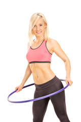 Fototapeta na wymiar Young woman exercising with a hula hoop