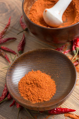 red hot pepper chili powder in a mortar and pods