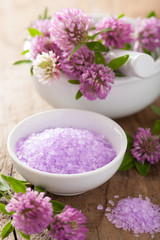Fototapeta na wymiar spa with purple herbal salt and clover flowers
