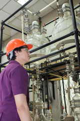 Engineer student looking part of machine in laboratory