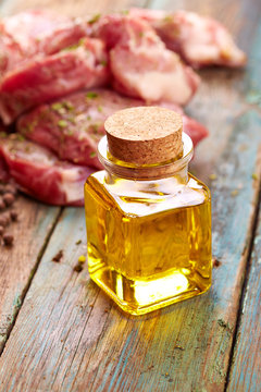 Raw steak and oil over wooden background