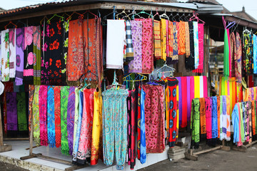 Rows of colourful silk scarfs hanging at a market stall in Indon