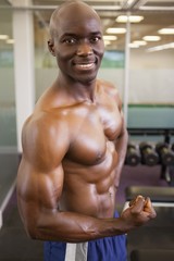 Fototapeta premium Smiling shirtless muscular man posing in gym