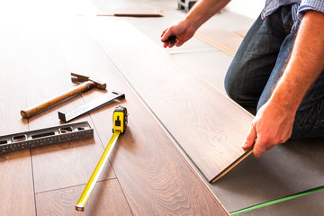 Fototapeta na wymiar Man installing new laminated wooden floor