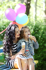 Obraz premium Happy mom and daughter. Walk in the green park