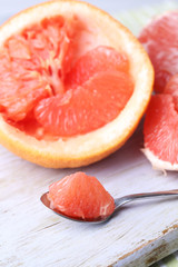Ripe grapefruits on cutting board, on wooden background