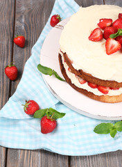 Delicious biscuit cake with strawberries on table close-up