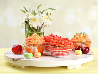 Tasty cupcakes on table, on bright background