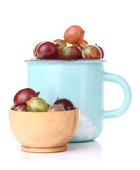 Ripe gooseberries in mug isolated on white.