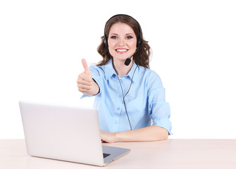Young woman with headset sitting at table with notebook in room