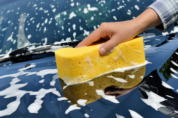 Car care - Washing a car with a sponge by hand.