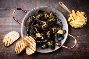 Rolgordijnen Mussels in copper cooking dish and french fries on dark wooden b © Natalia Lisovskaya