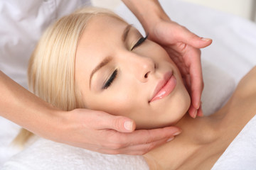Fototapeta na wymiar Beautiful young woman having massage in spa salon