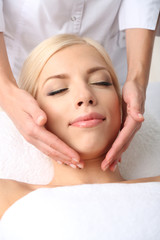 Beautiful young woman having massage in spa salon
