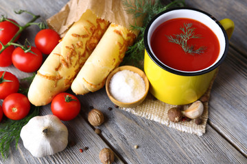 Homemade tomato juice in color mug, bread sticks, spices and
