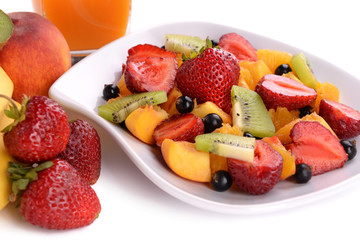 Fresh fruits salad on plate with berries and juice close up