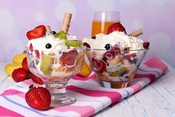 Fresh fruits salad with ice cream in bowls and juice