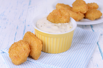 Chicken nuggets with sauce on table close-up