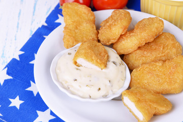 Chicken nuggets with sauce on table close-up