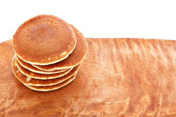 Stack of pancakes on wooden board with white background