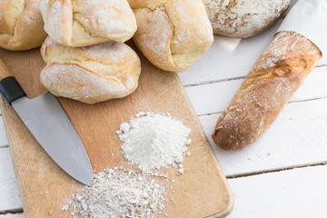 Ciabatta bread on wooden cutting board with knife