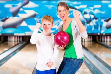 Naklejka premium Mother and son playing together at bowling center